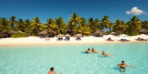 Tropical beach scene with celebrities enjoying their vacation.
